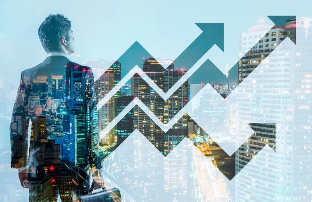 Double exposure of a businessman and upward financial graph over cityscape.