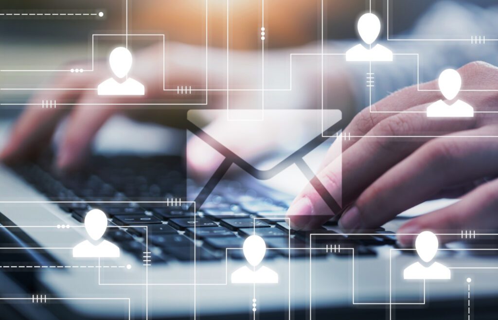 Person interacting with digital network icons over a laptop keyboard.