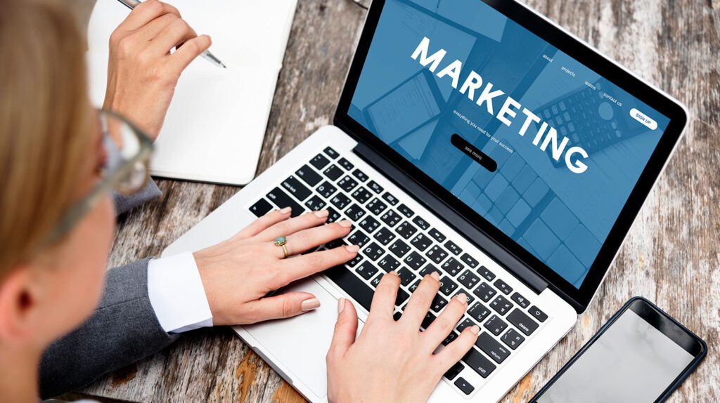 Two people collaborating on marketing strategies using a laptop.