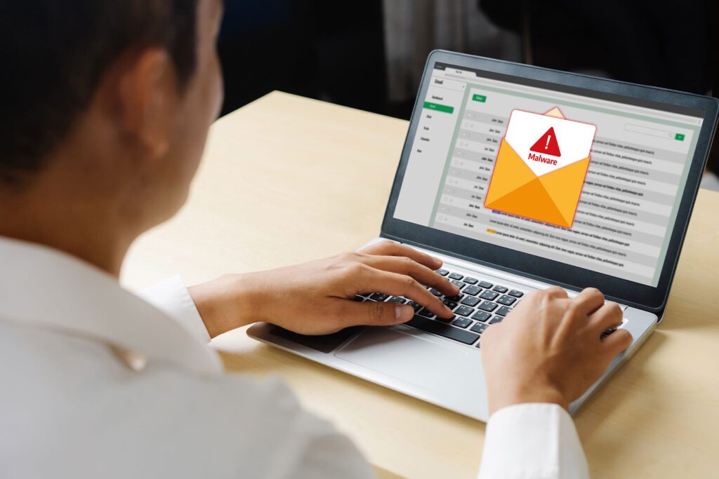 Person checking an email with a warning alert on a laptop.
