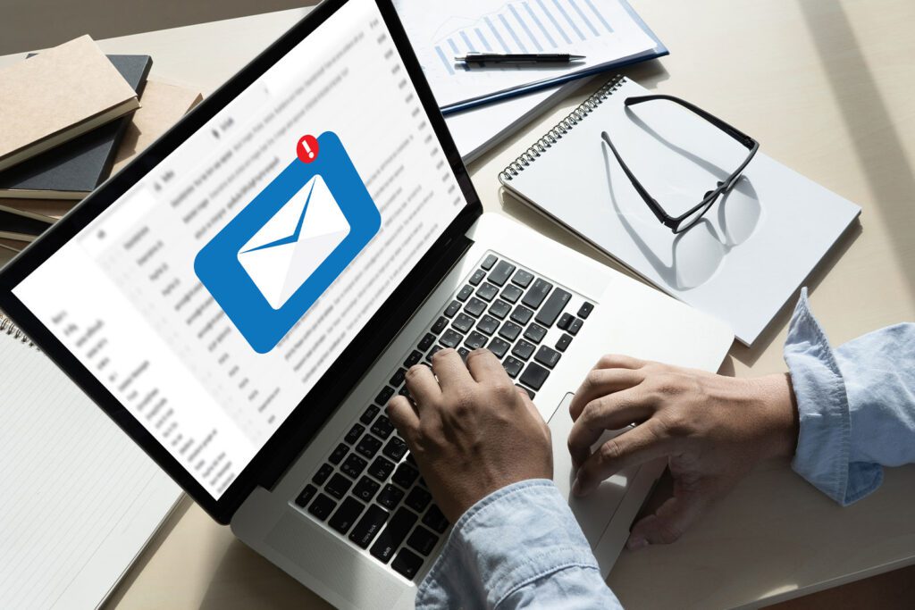 Person checking email notifications on a laptop at a desk.