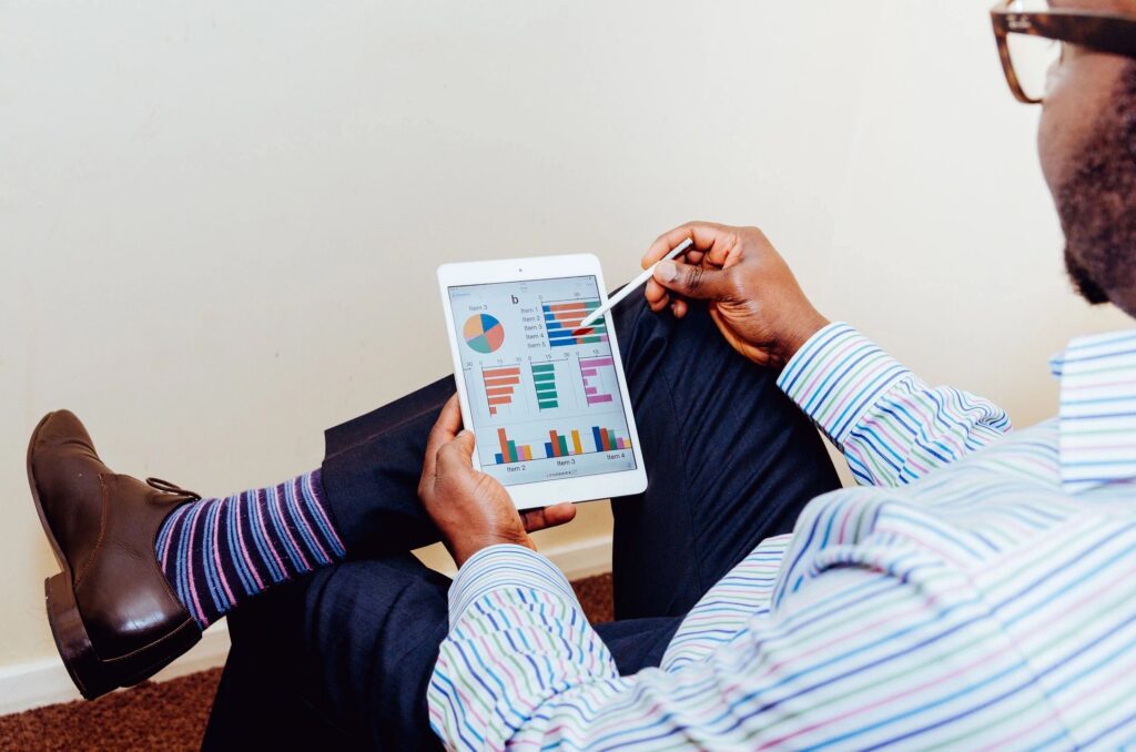 Person analyzing colorful charts and graphs on a tablet.