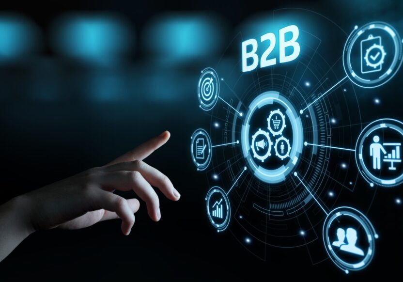 Hand interacting with futuristic B2B digital interface icons.