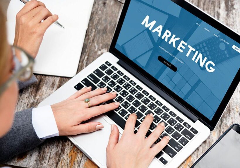 Two people collaborating on marketing strategies using a laptop.