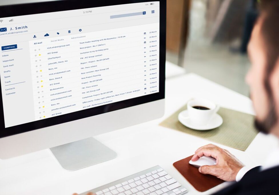 Person checking emails on a desktop computer.