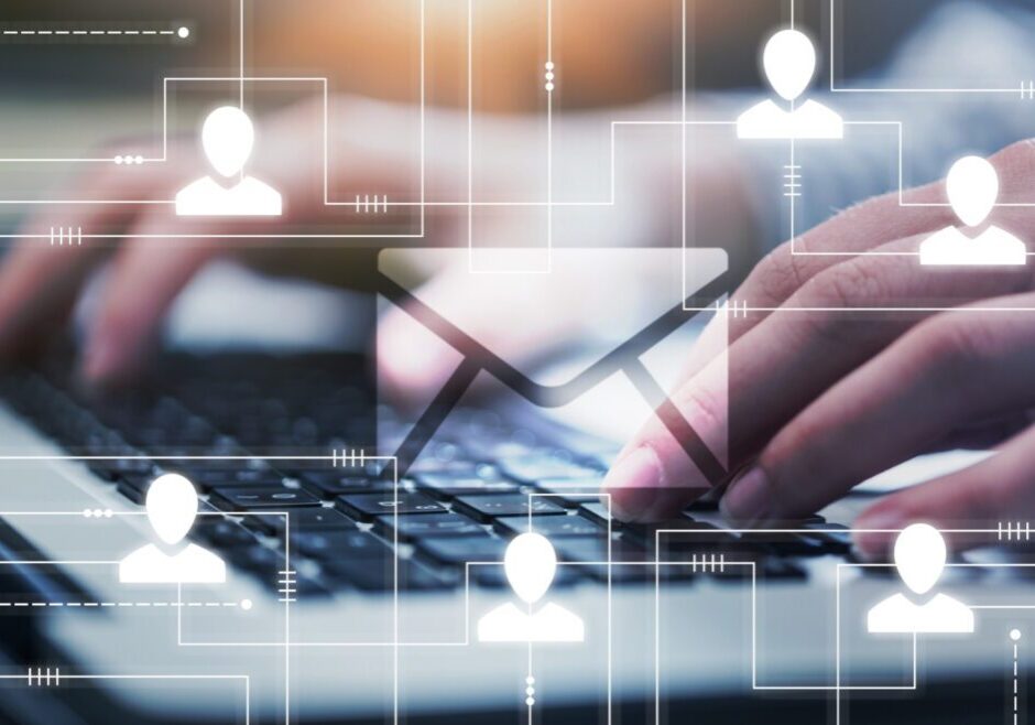 Person interacting with digital network icons over a laptop keyboard.