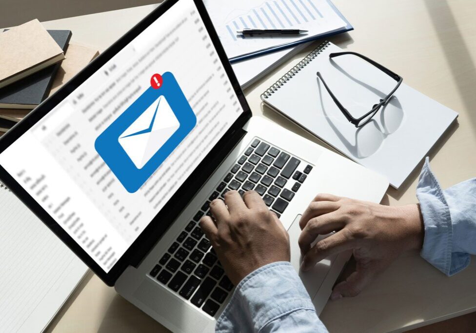 Person checking email notifications on a laptop at a desk.