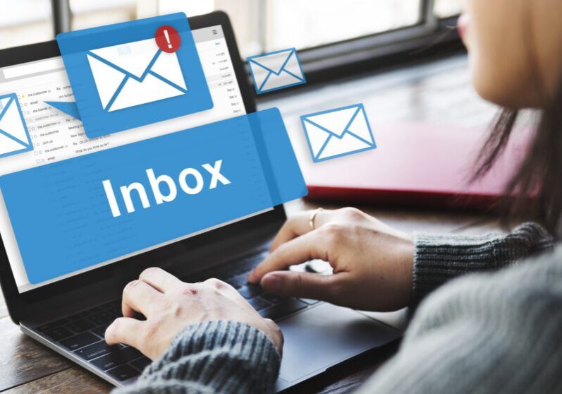 Person checking a crowded email inbox on a laptop.