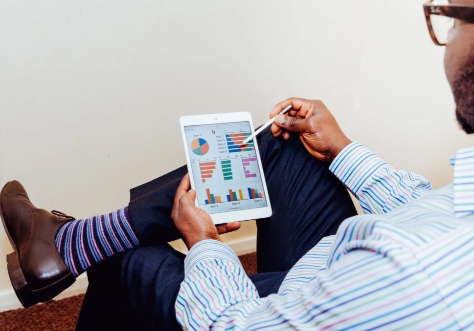 Person analyzing colorful charts and graphs on a tablet.