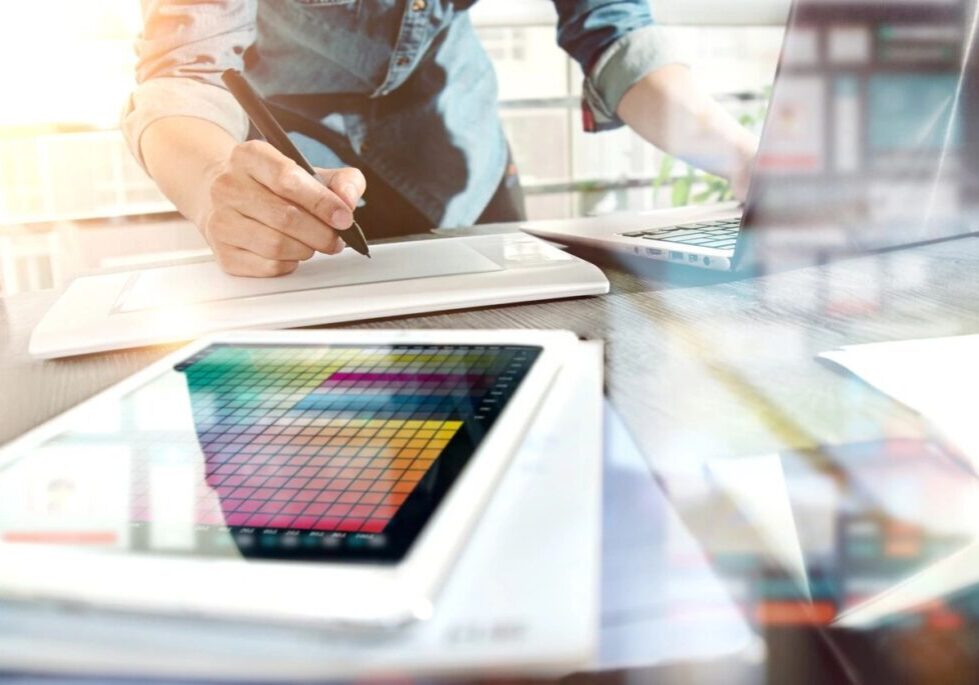 Person working on a digital tablet with color palette and stylus.